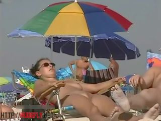 En dapper kvinne i en naken strand spionering kamera video